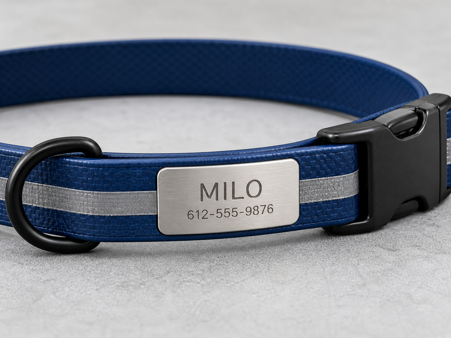 Close detail of integrated engraved metal nameplate, reflective strip and buckle